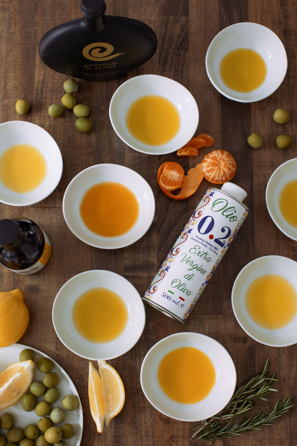 Olive oil bottles and bowls with olive oil on a wooden surface